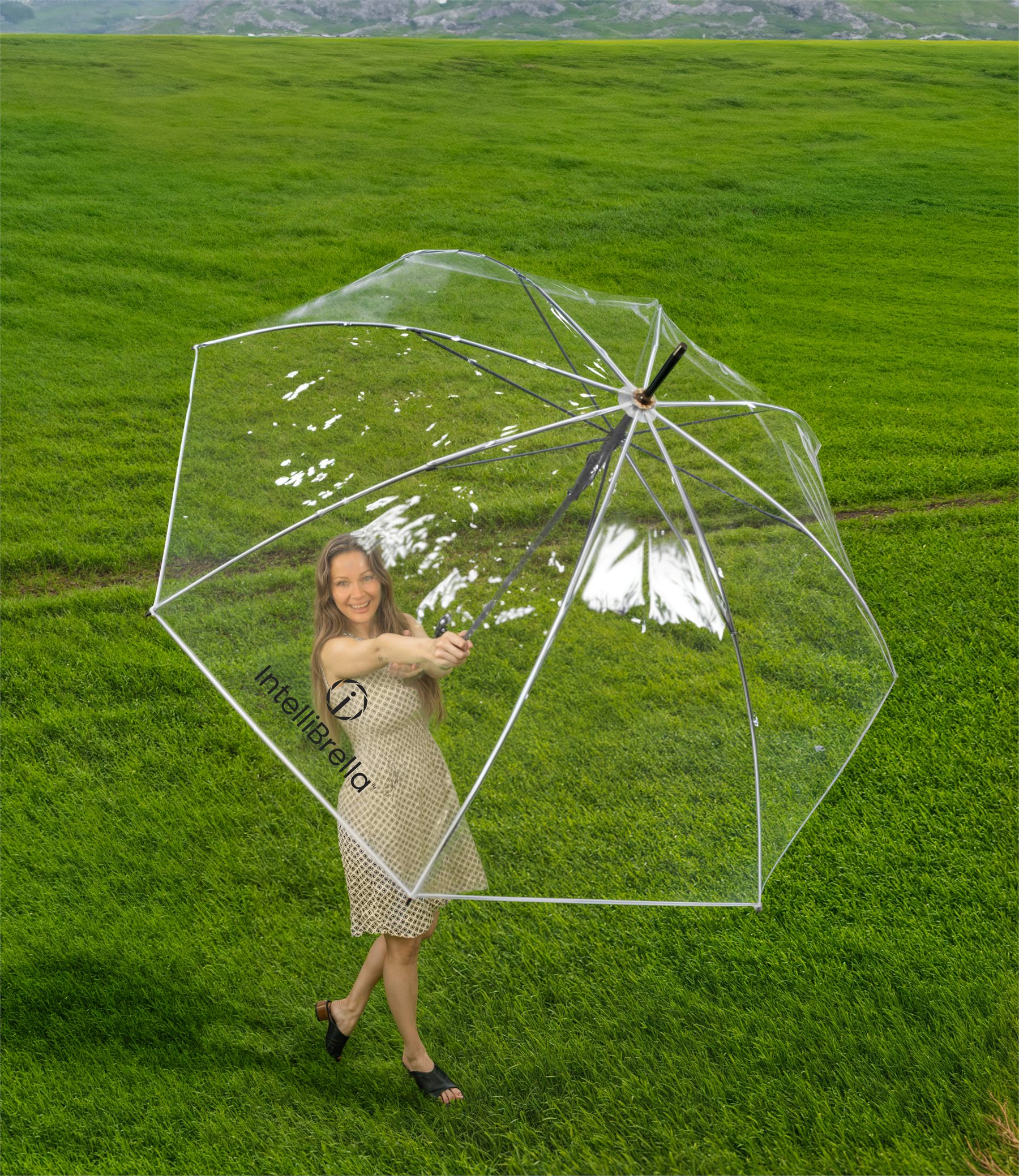 A person walking outdoors in the sun beneath the clear IntelliBrella™ canopy, surroundings fully visible
